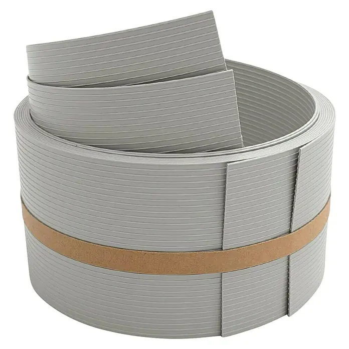 zaun|zu Sichtschutzstreifen Rille 1/2 - 2,55 m x 9,5 cm x 0,1 cm, Steingrau - Graues, aufgerolltes Sockelleistenprofil mit horizontalen Rillen und braunem Band zur Fixierung. Für Bodenbeläge und Innenausbau.