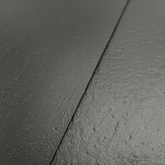 zaun|zu Sichtschutzstreifen Eco - 50 m x 19 cm x 0,1 cm, Schwarz, 1 Stk. - Nahaufnahme von zwei schwarzen Schieferplatten, die eine Textur und Tiefe zeigen. Ideal für Hintergründe oder Designelemente.