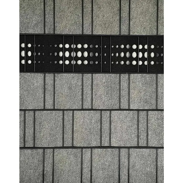 zaun|zu Sichtschutzstreifen Dekor Bubble - 2,6 m x 19 cm x 0,1 cm, Schwarzgrau - Nahaufnahme einer modernen Wandverkleidung mit grauen Paneelen und einem schwarzen, perforierten Akzentband. Einzigartige Textur und Muster für modernes Design.