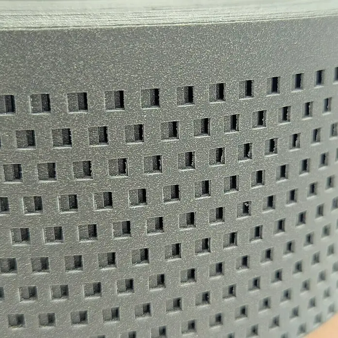 zaun|zu Sichtschutzstreifen Polyal Eco Quadratisch Gelocht - 50 m x 19 cm x 0,1 cm, Salbei - Nahaufnahme einer grauen Kunststoffplatte mit quadratischen Löchern.