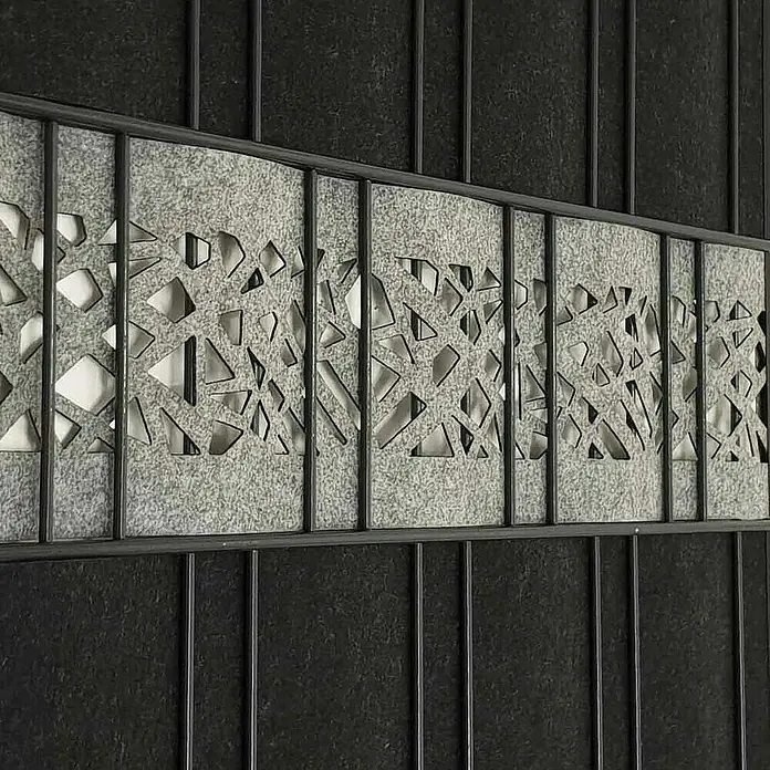 zaun|zu Sichtschutzstreifen Design Graphic - 2,6 m x 19 cm x 0,1 cm, Hellgrau - Nahaufnahme eines grauen, geometrisch gemusterten Gittereinsatzes in einer Tür, der ein dekoratives Element mit modernem Design hervorhebt.