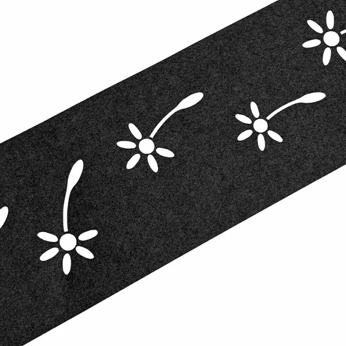 zaun|zu Sichtschutzstreifen Design Pusteblume - 2,55 m x 19 cm x 0,2 cm, Schwarzgrau - Nahaufnahme einer schwarzen Tischdecke mit gestanzten weißen Blumenmotiven, die eine subtile, elegante Note verleiht.