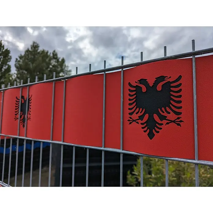 zaun|zu Sichtschutzstreifen Albanien - L x B x H: 2,55 m x 19 cm x 0,1 cm, Rot, Albanien, Akzentstreifen 3 Für 2 - Das Bild zeigt einen Zaun, der mit Flaggen von Albanien geschmückt ist. Die roten Flaggen mit dem schwarzen Doppeladler sind gut erkennbar.