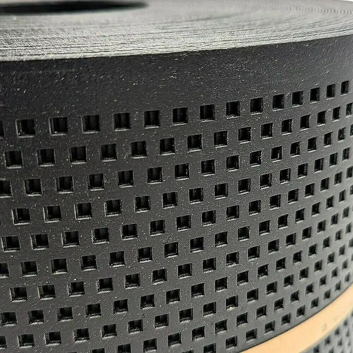zaun|zu Sichtschutzstreifen Polyal Eco Quadratisch Gelocht - 26 m x 19 cm x 0,1 cm, Schwarz - Nahaufnahme einer Rolle perforierten schwarzen Bandes mit quadratischen Löchern, ideal für verschiedene industrielle Anwendungen.