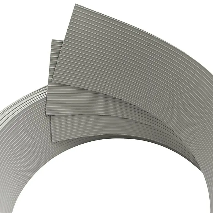 zaun|zu Sichtschutzstreifen Rille Drittel Set - 2,55 m x 6,3 cm x 0,1 cm, Steingrau - Nahaufnahme von einer Rolle grauer, gerippter Abdichtungsmasse.