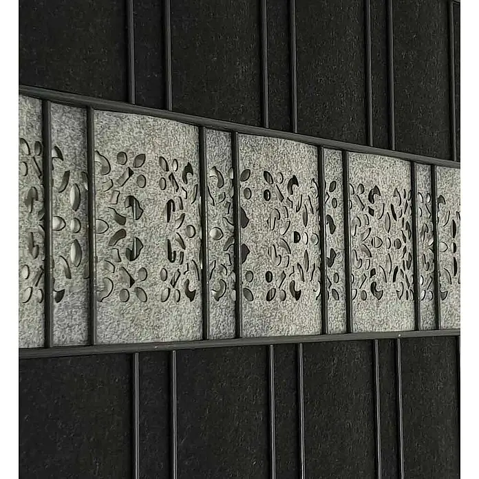zaun|zu Sichtschutzstreifen Ornament - 2,6 m x 19 cm x 0,2 cm, Hellgrau - Nahaufnahme eines dekorativen Metallelements mit floralen Ausschnitten, eingebettet in ein Gittermuster, das ein dekoratives Element hervorhebt.