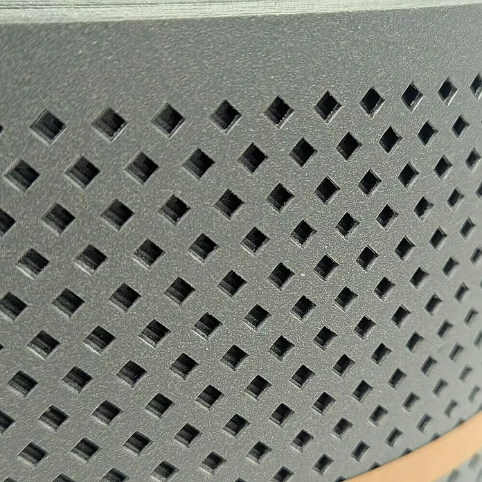 zaun|zu Sichtschutzstreifen Polyal Eco Gelocht Diamant - 50 m x 19 cm x 0,1 cm, Salbei - Nahaufnahme einer perforierten, anthrazitfarbenen Oberfläche mit quadratischen Aussparungen.