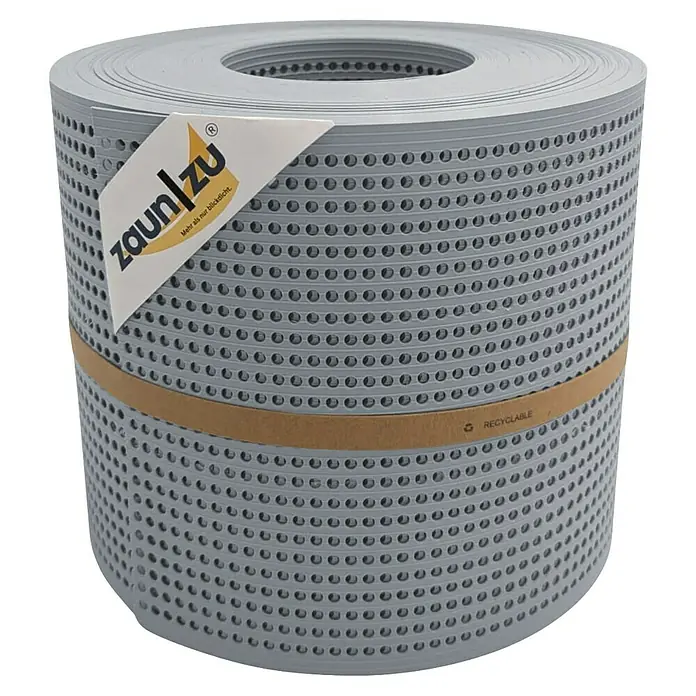 zaun|zu Sichtschutzstreifen Rille Gelocht 30% PP - 26 m x 19 cm x 0,1 cm, Fenstergrau - Eine Rolle grauer Zaunfolie mit Lochmuster, die mit einem Papieretikett und einem Recycling-Band versehen ist.