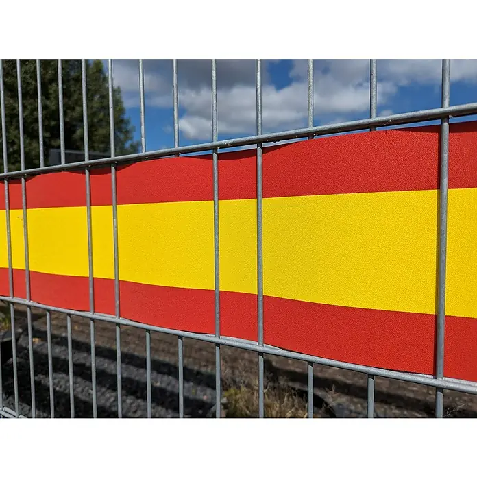 zaun|zu Sichtschutzstreifen Spanien - 19 x 0,1 cm, Rot/Gelb, Schmal 3 Für 2 - Blick auf einen Zaun mit der spanischen Flagge, die rot und gelb gestreift ist. Das Tor hat ein Muster und die Farben stechen hervor.