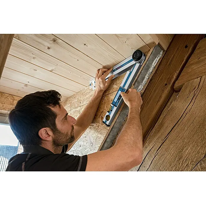 Bosch Professional Digitaler Winkelmesser GAM 220 - Messbereich: 0 - 220 ° - Ein Handwerker benutzt einen Bosch Digital-Winkelmesser, um Winkel in einem Holzrahmen zu messen. Er erzielt akkurate Ergebnisse mit diesem Werkzeug.