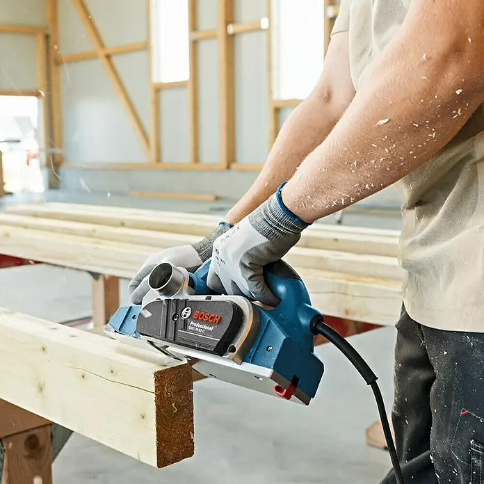 Bosch Professional Handhobel GHO 26-82 D - 710 W, Hobeltiefe: 0 mm - 2,6 mm, Leerlaufdrehzahl: 18.000 U/min - Nahaufnahme eines Bosch Elektrohobels in Aktion, ideal zum Glätten von Holzoberflächen.