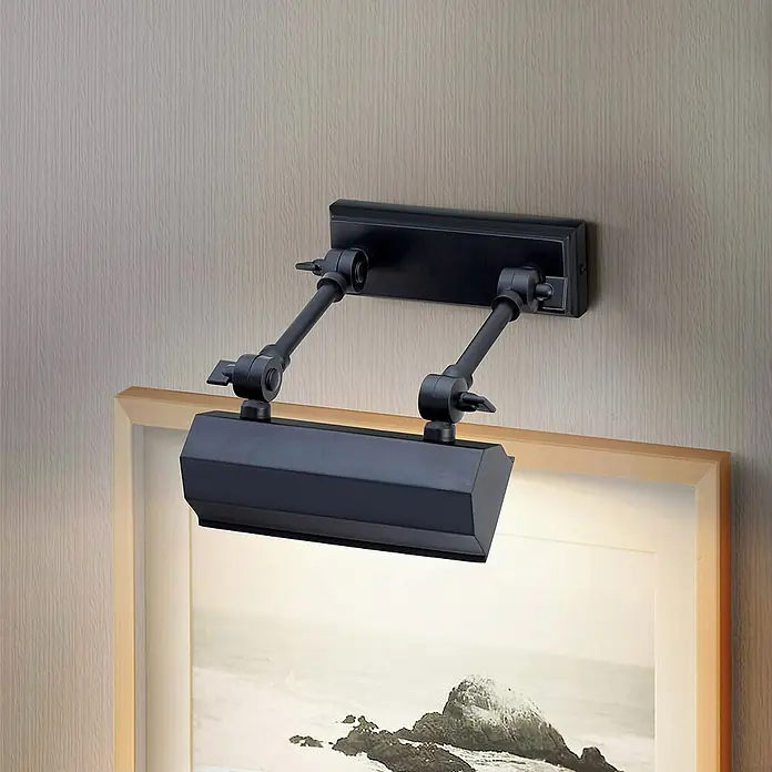 Elstead LED-Bilderleuchte Chawton - 40 W, L x B x H: 18,6 x 18,2 x 11,9 cm, Schwarz - Nahaufnahme einer schwarzen, verstellbaren Bilderleuchte, die ein gerahmtes Gemälde an einer strukturierten Wand beleuchtet.