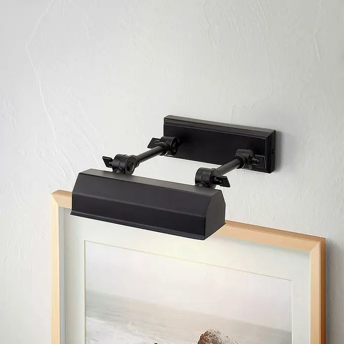 Elstead LED-Bilderleuchte Chawton - 40 W, L x B x H: 18,6 x 18,2 x 11,9 cm, Schwarz - Nahaufnahme einer schwarzen Bilderleuchte, die an einer Wand montiert ist und ein gerahmtes Kunstwerk beleuchtet.