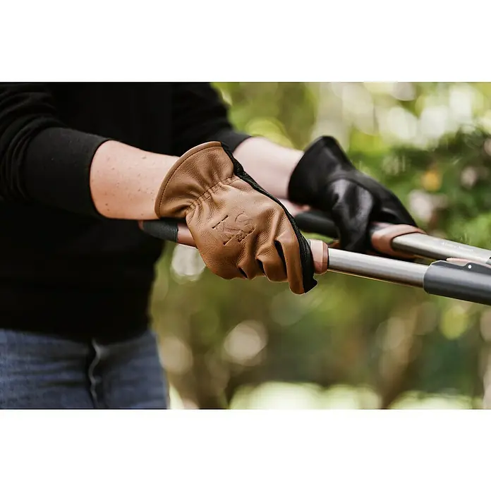 Kent & Stowe Gartenhandschuhe Sure & Soft - S, Braun/Schwarz - Detailaufnahme von Händen, die Gartenhandschuhe tragen und Heckenscheren halten. Optimaler Schutz bei der Gartenarbeit.