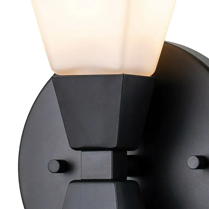 Elstead LED-Wandleuchte Bowtie - 3 W, L x B x H: 10,2 x 15,2 x 24,8 cm, Schwarz - Nahaufnahme einer mattschwarzen Wandleuchte mit einem cremefarbenen Lampenschirm, der ein warmes Licht ausstrahlt.
