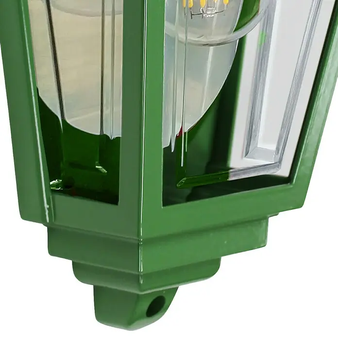 Elstead Außenwandleuchte Deco lane - 60 W, 11 x 32,5 x 32,5 cm, Grün, IP44 - Nahaufnahme einer grünen Laterne mit klaren Scheiben und einer Glühbirne, die ein sanftes Licht ausstrahlt. Die Laterne ist modern und stilvoll.