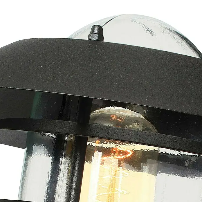 Elstead Außenwandleuchte Helsingor - 50 W, 26 x 21,8 x 23,6 cm, Schwarz, IP44 - Nahaufnahme einer schwarzen Außenleuchte mit einer klaren Glühbirne, die ein warmes Licht ausstrahlt.