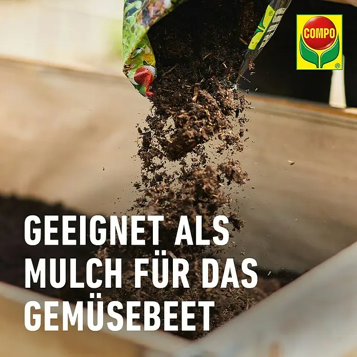 Compo Hochbeetmulch - 50 l - Das Bild zeigt COMPO Mulch, der aus einer Tüte in ein Gemüsebeet gegossen wird. Geeignet als Mulch für das Gemüsebeet.