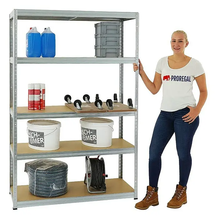 Proregal Schwerlastregal Mega Deal Big Elephant S - Traglast pro Boden: 250 kg, Anzahl Böden: 5 Stk., Stecken, Verzinkt - Lagerregal mit fünf Regalböden, beladen mit verschiedenen Gegenständen, und eine Frau steht daneben.
