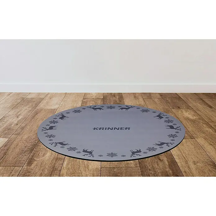 Krinner Dekoartikel - L x B x H: 60 x 60 x 0,7 cm, Grau - Graue Krinner Christbaumständer-Unterlage mit Rentier- und Schneeflockenmuster auf einem Holzboden vor einer weißen Wand.