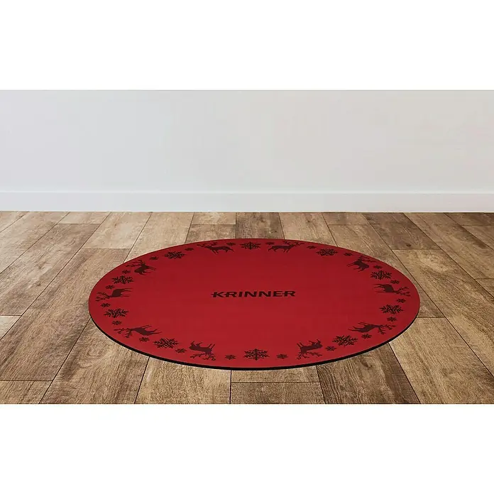 Krinner Dekoartikel - L x B x H: 60 x 60 x 0,7 cm, Rot - Runder, roter Weihnachtsbaumständer von KRINNER mit Rentier- und Schneeflockenmuster auf einem Holzboden vor einer weißen Wand.