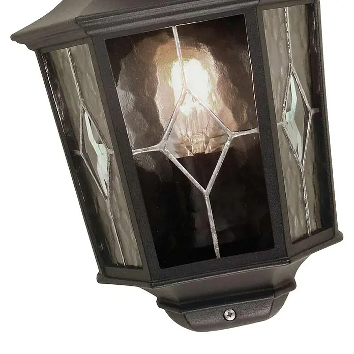 Elstead Außenwandleuchte Norfolk - 60 W, 12,5 x 35,9 x 39,5 cm, Schwarz, IP44 - Nahaufnahme einer schwarzen Laterne mit gemustertem Glas und einer warmen Glühbirne, die ein gemütliches Licht ausstrahlt.