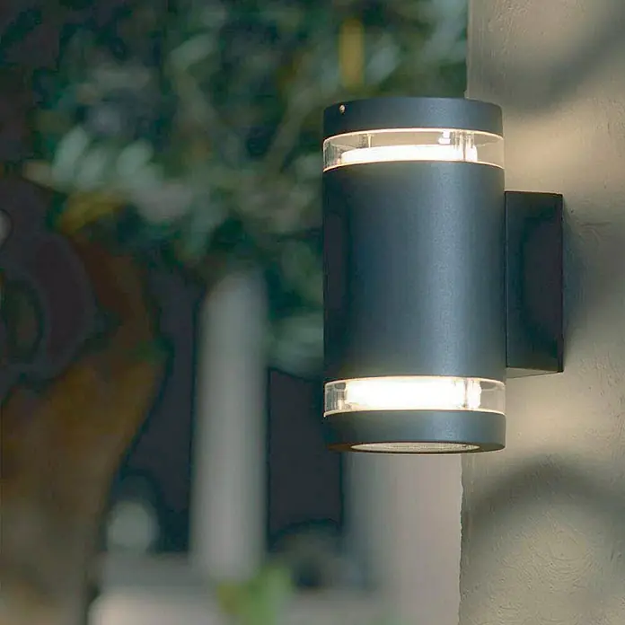 Elstead LED-Außenleuchte Magnus - Farbe Gehäuse: Graphite, IP44, 5,7 W, Anzahl Leuchtmittel: 2 Stk. - Nahaufnahme einer modernen, zylindrischen Außenwandleuchte in Anthrazit, die warmes Licht nach oben und unten abgibt.