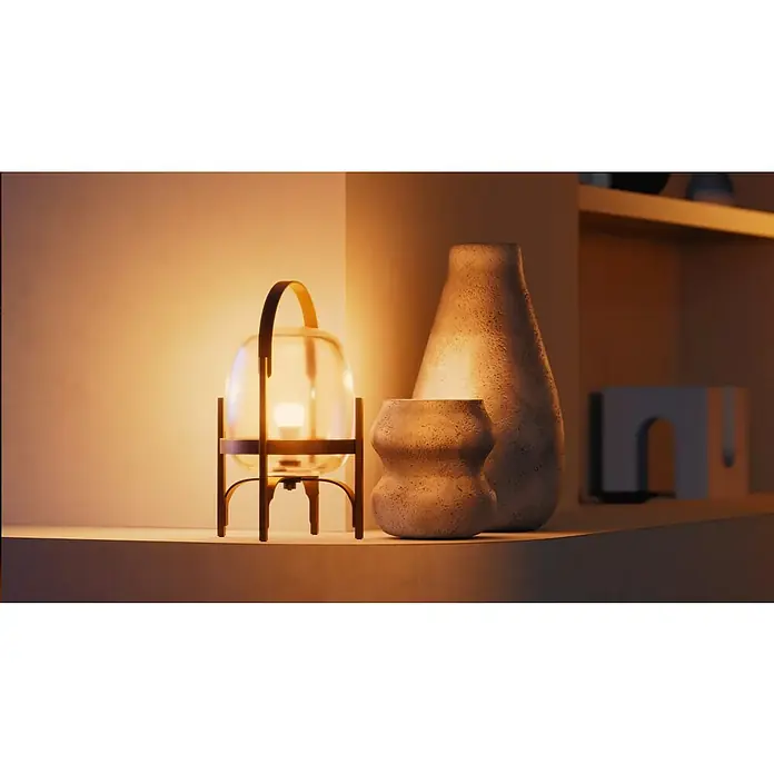 Philips Hue Smart-LED-Lampen Set White 1100 matter - E27, Dimmbar, Warmweiß, 1.100 lm, 9,5 W, 2 Stk. - Ein stimmungsvolles Stillleben mit einer Laterne, Vasen und dekorativen Elementen auf einem Regal, das warmes Licht ausstrahlt.
