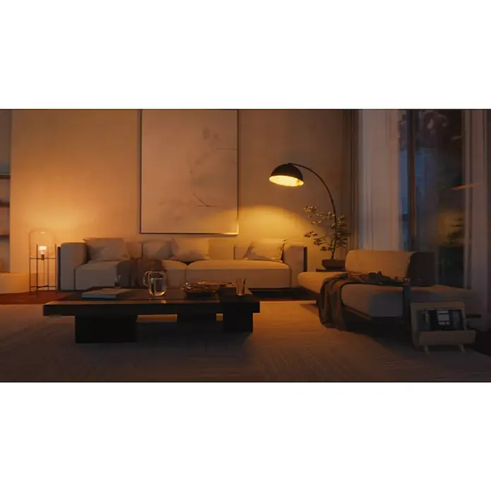 Philips Hue Smart-LED-Lampe White Ambiance 1600 matter - E27, Dimmbar, Kaltweiß, 1.600 lm, 11,8 W - Das Bild zeigt ein stimmungsvolles Wohnzimmer mit einer einladenden Couch und einem eleganten Couchtisch in warmen Farbtönen.