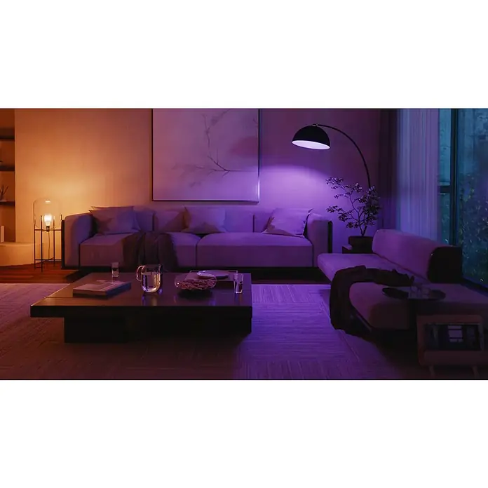 Philips Hue Smart-LED-Lampe White and Color 1100 matter - E27, Dimmbar, RGB, 1.100 lm, 8,1 W - Gemütliches Wohnzimmer mit sanfter Beleuchtung, das eine entspannende Atmosphäre schafft. Die Sofas laden zum Verweilen ein.