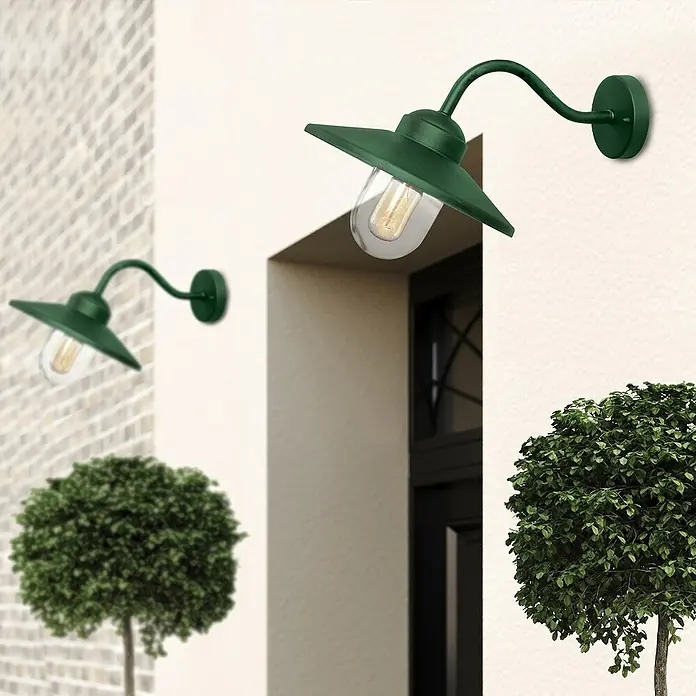 Elstead Außenwandleuchte Klampenborg - 60 W, 31,8 x 31,8 x 31,8 cm, Fir Green, IP44 - Grüne Außenleuchte mit gebogenem Arm und klarem Glas vor einer Fassade.