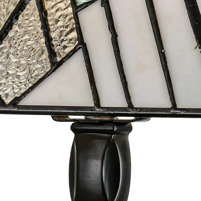 Elstead Alderley Tischleuchte Tiffany - 40 W, L x B x H: 20,6 x 20,6 x 35 cm, Braun, Beige, E14 - Nahaufnahme einer Tiffany-Lampe mit geometrischen Formen in Weiß und strukturiertem Glas, eingefasst in dunkles Metall, auf einem verzierten Sockel.