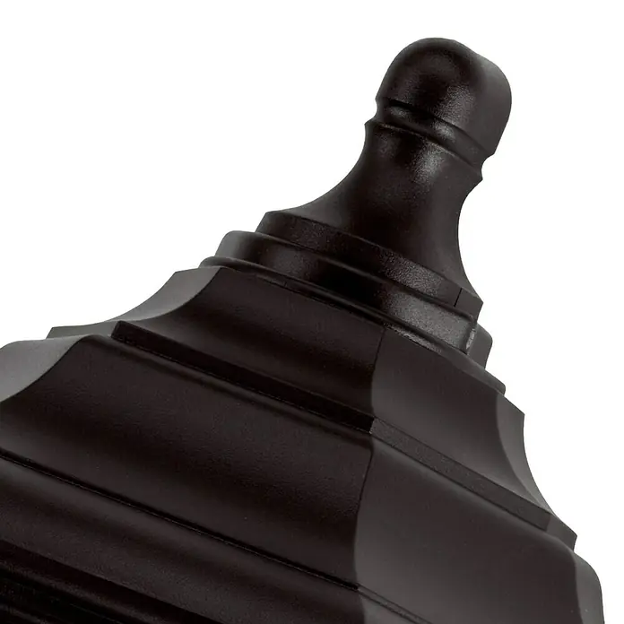 Elstead Außenwandleuchte Kinsale - 60 W, 12,7 x 44 x 44 cm, Schwarz, IP44 - Nahaufnahme einer eleganten, dunklen Treppenpfostenkappe. Das detailreiche Design und die hochwertige Verarbeitung machen sie zu einem Blickfang.