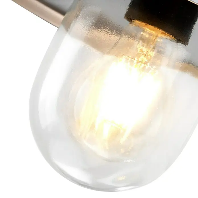 Elstead Außenwandleuchte Klampenborg - 60 W, 31,8 x 31,8 x 31,8 cm, Silber, IP44 - Nahaufnahme einer hellen Glühbirne in einer klaren, tropfenförmigen Glasfassung. Die Glühbirne strahlt warmes Licht aus.