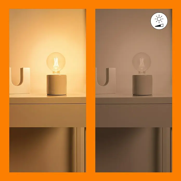 Philips Wiz Smart-LED-Lampe - E27, Dimmbar, Mehrfarbig, 806 lm, 6,7 W, G125 - Darstellung einer dimmbaren Tischleuchte mit rundem Schirm und Keramikfuß auf einem Nachttisch, in zwei Helligkeitsstufen.