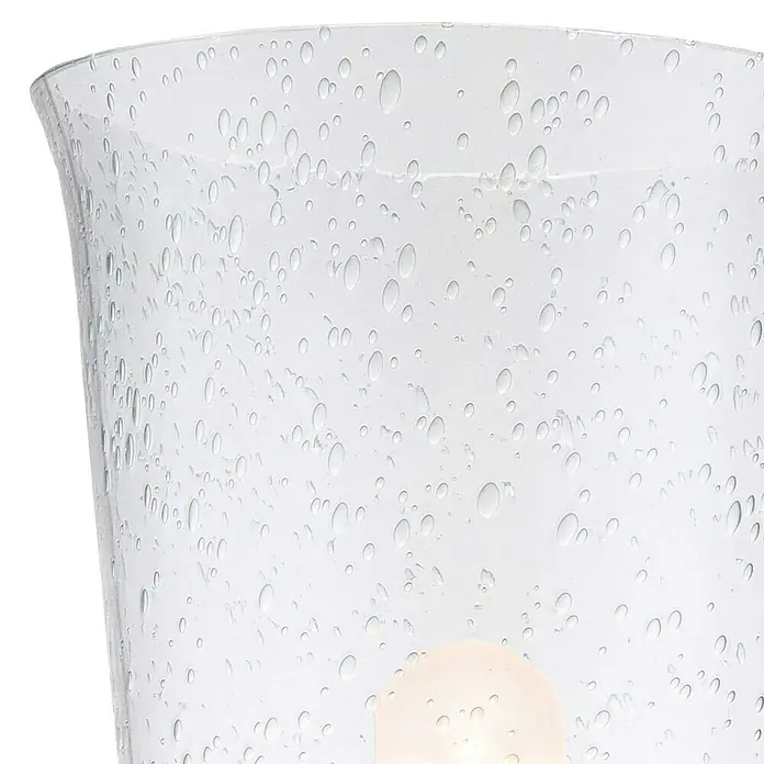 Elstead LED-Wandleuchte Hugenot - 3 W, L x B x H: 15,2 x 13,3 x 24,8 cm, Messing, Warmweiß - Nahaufnahme einer durchsichtigen Glasvase mit unregelmäßigen Punkten, die einen faszinierenden visuellen Effekt erzeugen.\n