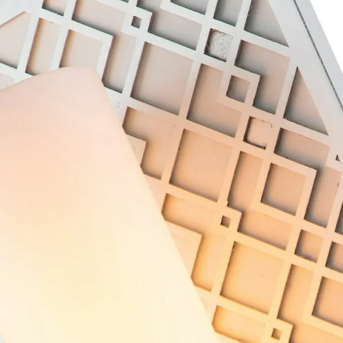 Elstead Wandleuchte Ziggy - 40 W, L x B x H: 11,4 x 15,2 x 34,3 cm, Silber, E27 - Nahaufnahme einer modernen Lampe mit einem cremefarbenen Lampenschirm und einem dekorativen, geometrischen Lampenfuß in Weiß.
