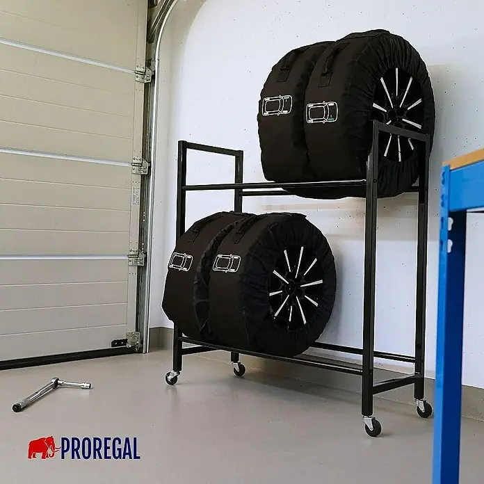 Proregal Reifenregal CARRERO - Schrauben, Schwarz - Ein rollbarer Reifenständer mit vier in Reifenhüllen verpackten Reifen in einer Garage.