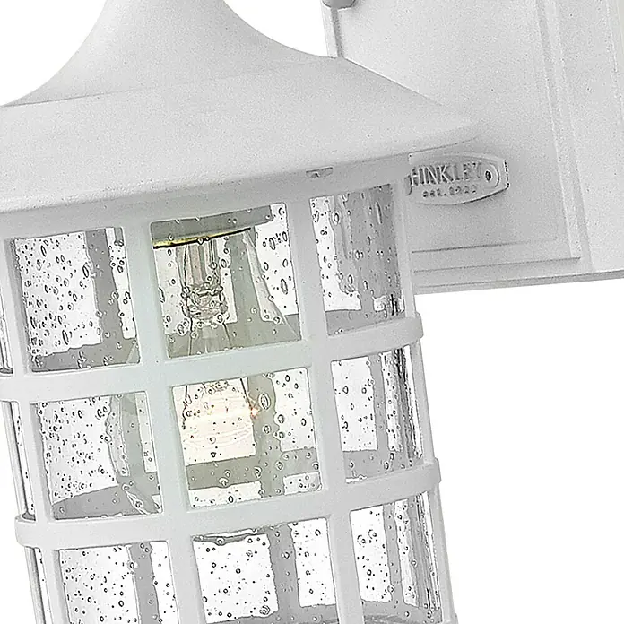 Elstead Außenwandleuchte Freeport - 60 W, 18,5 x 23,8 x 23,8 cm, Weiß, IP44 - Nahaufnahme einer weißen HINKLEY Außenleuchte mit einem dekorativen Glaskörper und sichtbarer Glühbirne.