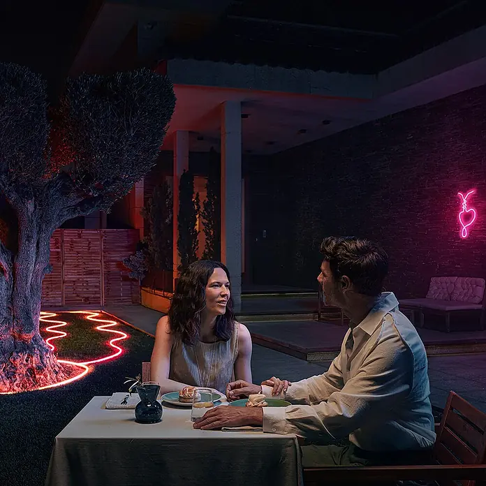 Philips Hue LED-Stripes Outdoor White and Color Gradient Neon - Länge: 5 m, Lichtfarbe: RGBW, 3.000 lm, 30 W - Romantisches Abendessen im Freien, beleuchtet mit innovativen LED-Leuchten, die eine warme Atmosphäre schaffen.