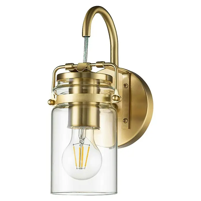 Elstead Wandleuchte Brinley - 60 W, L x B x H: 15,9 x 12,7 x 29,2 cm, Messing, E27 - Nahaufnahme einer goldenen Wandleuchte mit klarem Glas und einer Edison-Glühbirne, die warmes Licht ausstrahlt.