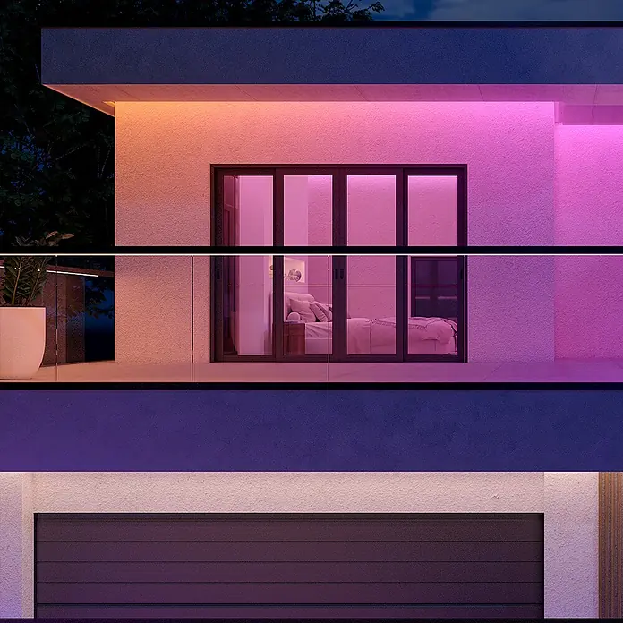Philips Hue LED-Stripes Outdoor White and Colours Gradient Flux - Länge: 10 m, Lichtfarbe: RGBW, 3.000 lm, 30 W - Nahaufnahme eines modernen Hauses mit LED-Beleuchtung, die eine stimmungsvolle Atmosphäre erzeugt.\n