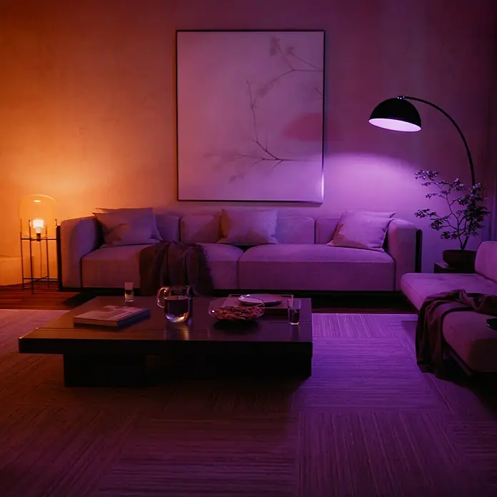 Philips Hue Smart-LED-Lampen Set White and Color 1100 matter - E27, Dimmbar, RGB, 1.100 lm, 8,1 W, 2 Stk. - Elegantes Wohnzimmer mit stilvollem Sofa, Couchtisch und Kunstwerk, beleuchtet durch eine moderne Stehlampe.