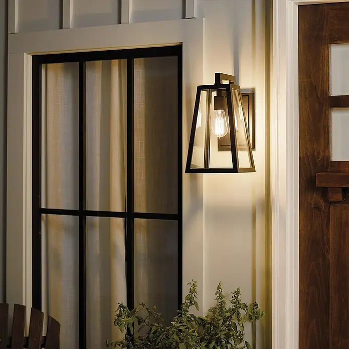 Elstead Außenwandleuchte Delison - 60 W, 25,4 x 35,7 x 35,7 cm, Schwarz, IP44 - Nahaufnahme einer stilvollen, schwarzen Außenwandleuchte mit klarem Glas und einer warm leuchtenden Edison-Glühbirne.