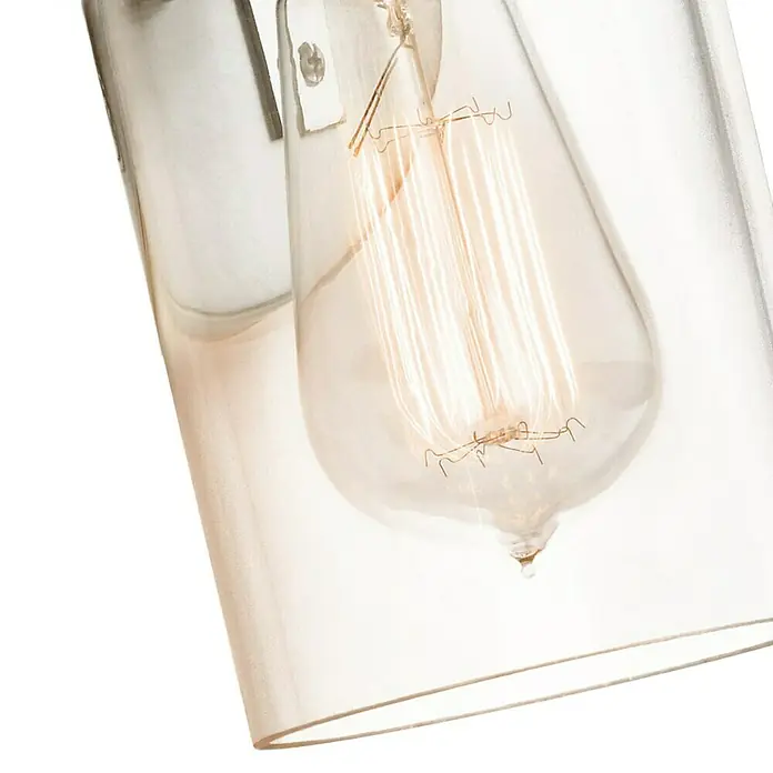 Elstead Wandleuchte Brinley - 60 W, L x B x H: 15,9 x 12,7 x 29,2 cm, Nickel, E27 - Nahaufnahme einer dekorativen Edison-Glühbirne in einer klaren Glasleuchte, die ein warmes, einladendes Licht ausstrahlt.