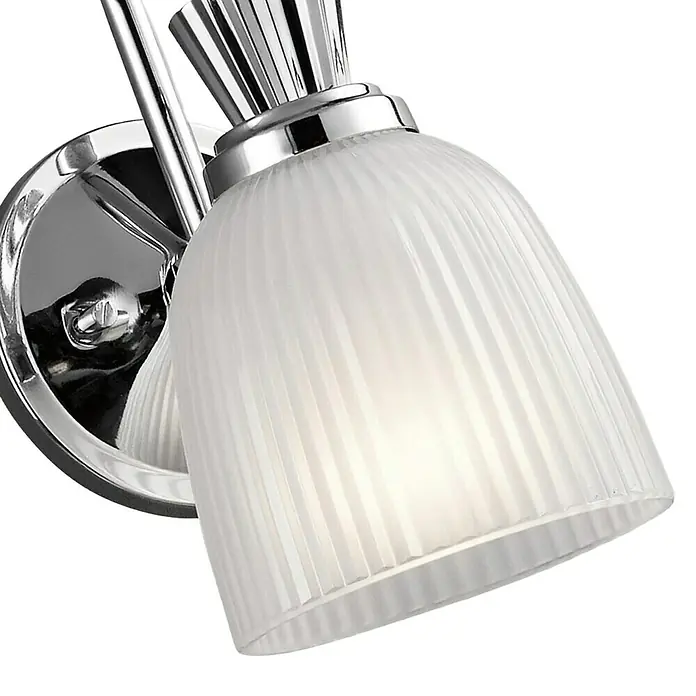 Elstead LED-Wandleuchte Cora - 3 W, L x B x H: 17,2 x 12,7 x 24,1 cm, Chrom, Warmweiß - Nahaufnahme einer eleganten Wandleuchte mit geripptem Glasschirm und polierter Chromoberfläche, die ein warmes Licht ausstrahlt.