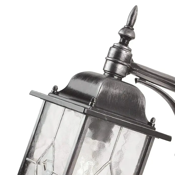 Elstead Außenwandleuchte Wexford - 60 W, 28,6 x 37 x 37 cm, Schwarz/Silber, IP23 - Detailaufnahme einer silberfarbenen Außenleuchte im klassischen Stil mit klaren Glasscheiben und dekorativen Elementen.