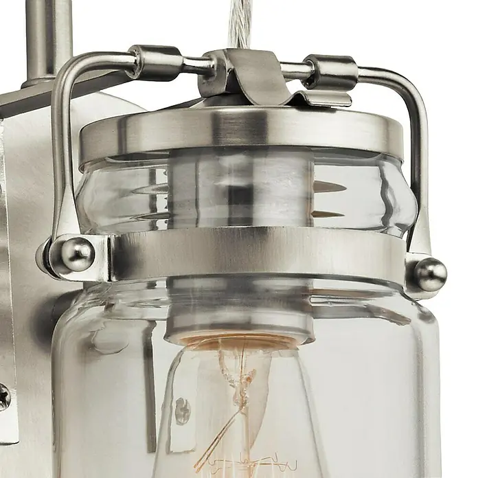 Elstead Wandleuchte Brinley - 60 W, L x B x H: 15,9 x 12,7 x 29,2 cm, Nickel, E27 - Nahaufnahme einer Wandleuchte im Vintage-Stil mit einem klaren Glasgefäß und Metallelementen in gebürstetem Nickel.
