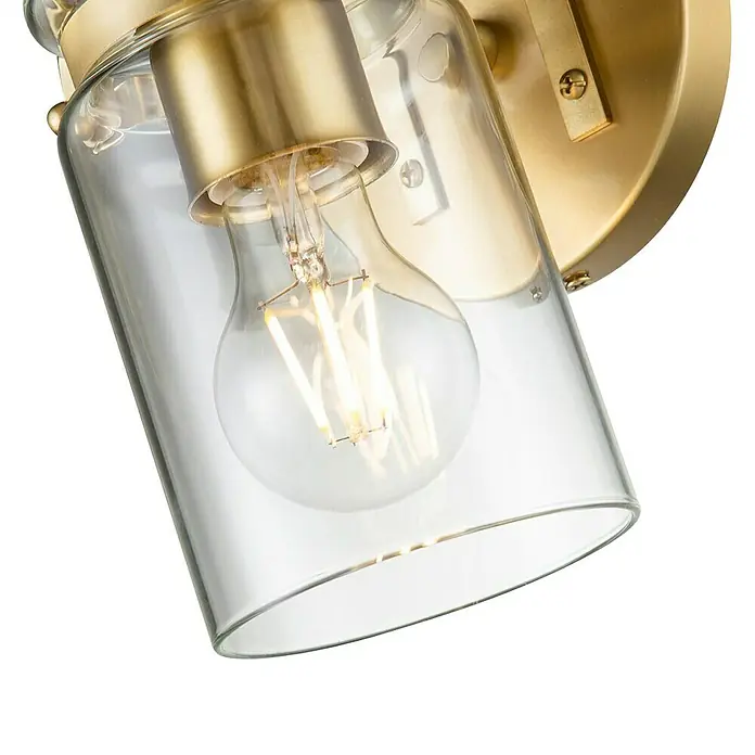 Elstead Wandleuchte Brinley - 60 W, L x B x H: 15,9 x 12,7 x 29,2 cm, Messing, E27 - Nahaufnahme einer eleganten Wandleuchte mit klarem Glasschirm und goldener Fassung, die ein warmes, einladendes Licht verbreitet.