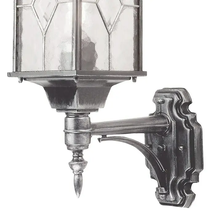 Elstead Außenwandleuchte Wexford - 60 W, 28,5 x 53,5 x 53,5 cm, Silber, IP44 - Diese Nahaufnahme zeigt eine silberfarbene Wandleuchte mit einer klaren Glasabdeckung und einem dekorativen Arm.